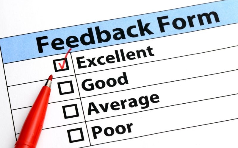 A notepad with “Feedback Form” at the top. There is a red pen that is marked “Excellent.” There are also options that read "good," "average,” and "poor."